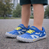Detalle de bebe zapatillas azules Saguaro Kids Vitality III en entorno de juego infantil.