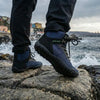 Hombre usando botas de trekking minimalistas Saguaro Vitality V azul, resistencia y comodidad para senderismo intenso.
