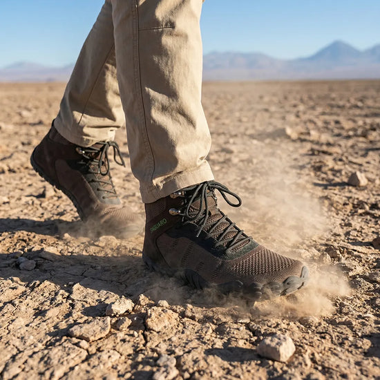 Hombre usando botas de trekking minimalistas Saguaro Vitality V café, resistencia y comodidad para senderismo intenso.