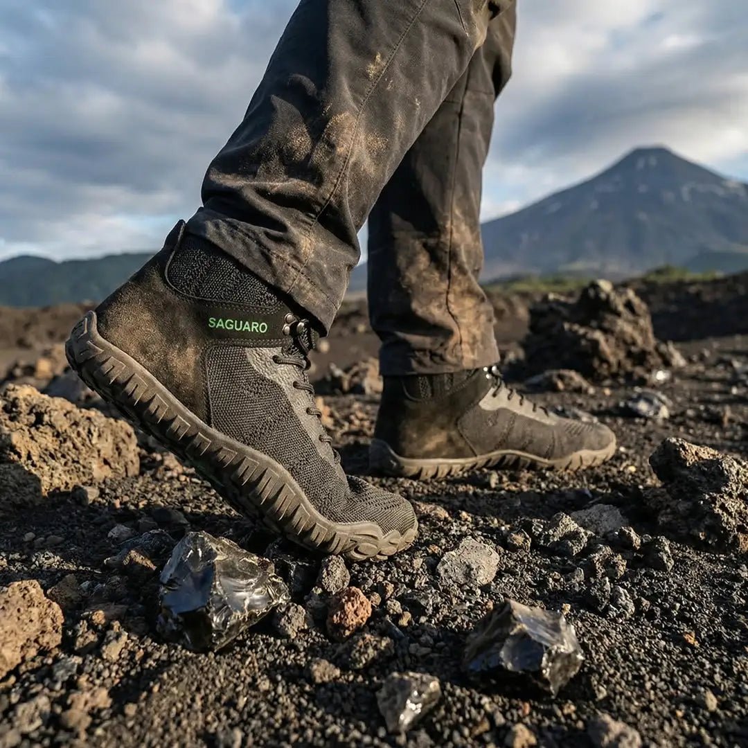 Hombre usando botas de trekking minimalistas Saguaro Vitality V negras, resistencia y comodidad para senderismo.