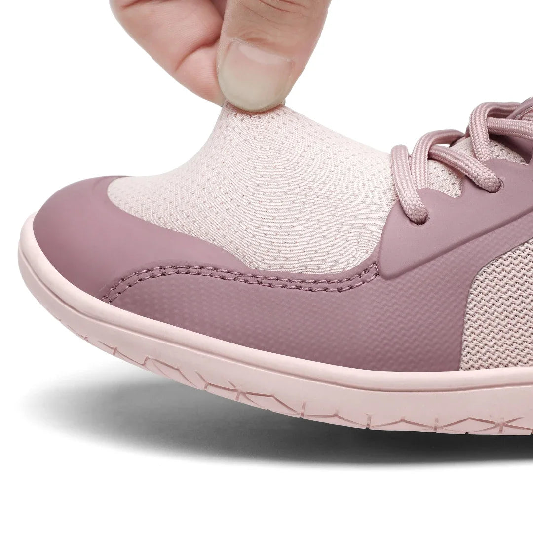 Detalle del material tejido transpirable de zapatilla rosa.