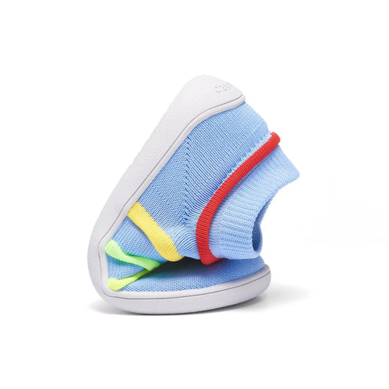 Zapatilla infantil azul doblada mostrando su total flexibilidad.
