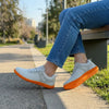 Mujer sentada con zapatilla minimalista ZZFaber gris.