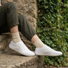 Persona usando zapatillas Saguaro Luck I blanco en entorno urbano.