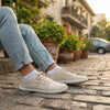 Persona usando zapatillas Saguaro Luck II crema en la ciudad.