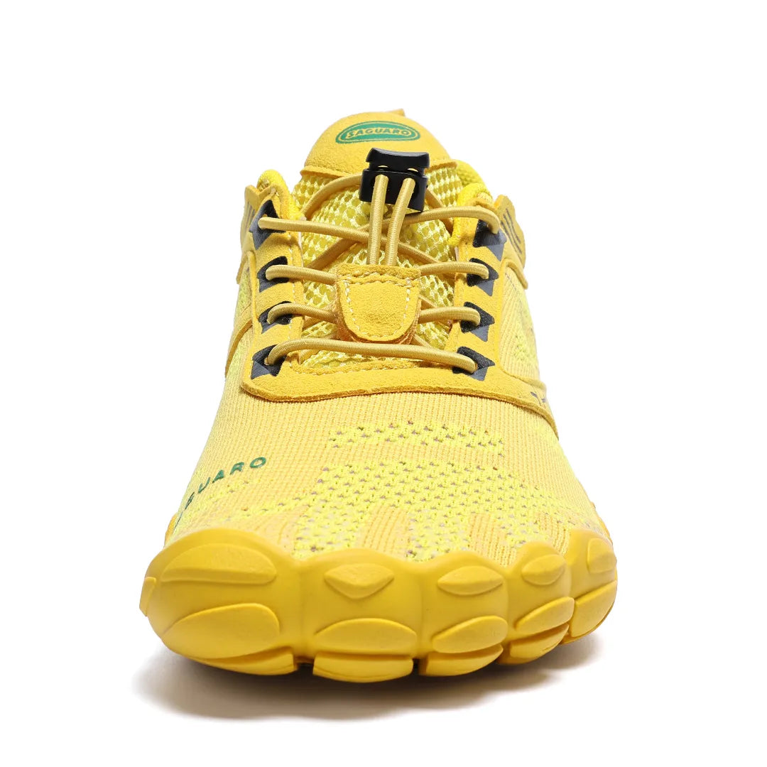 Vista frontal zapatilla deportiva amarilla, espacio amplio para dedos (toe box).