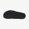 Suela plana negra de una zapatilla barefoot con diseño de burbujas antideslizantes.