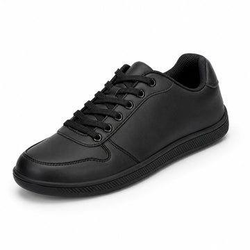 Zapatilla minimalista negra de piel sintética, estilo urbano y oficina.