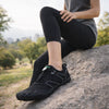 Mujer usando zapatillas barefoot negras para entrenamiento funcional en exteriores, destacando grip y estabilidad.