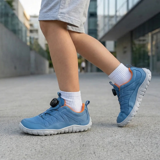 Niño jugando al aire libre con zapatillas barefoot Saguaro Forestep I azul, calzado respetuoso y flexible para el verano.
