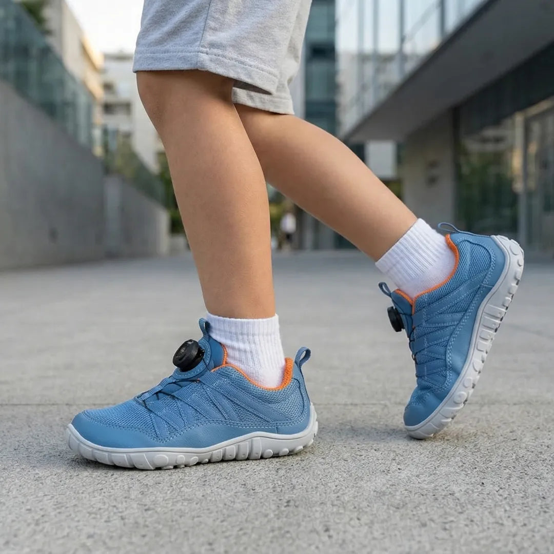 Niño jugando al aire libre con zapatillas barefoot Saguaro Forestep I azul, calzado respetuoso y flexible para el verano.