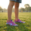 Niña utilizando Zapatillas barefoot Saguaro Kids Fast I rosa en un parque.