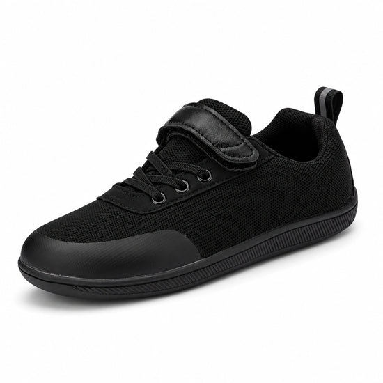 Zapato escolar barefoot negro para niño con puntera reforzada y suela flexible.