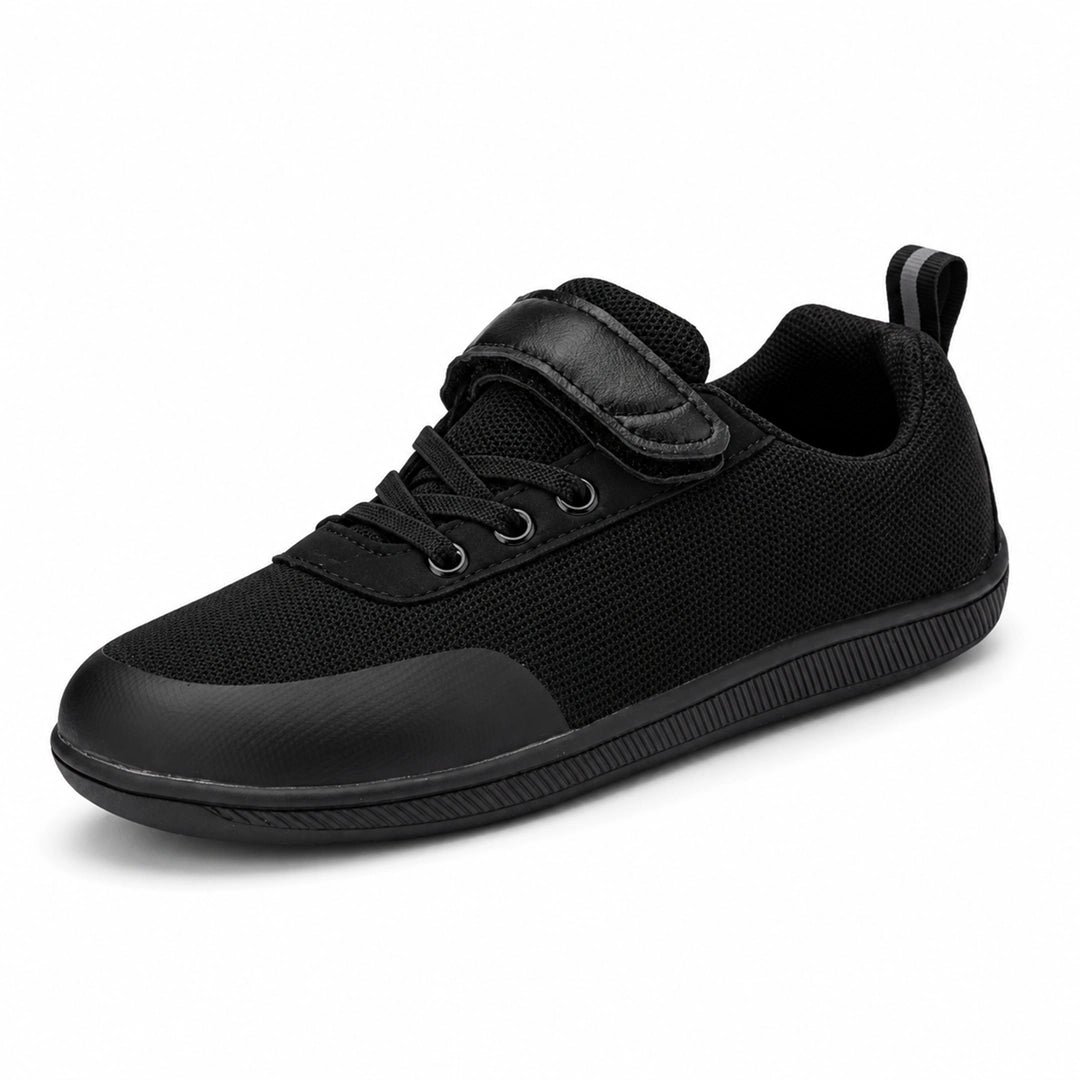 Zapato escolar barefoot negro para niño con puntera reforzada y suela flexible.